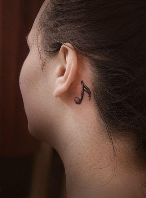 Татуировка стилизованной ноты за ухом